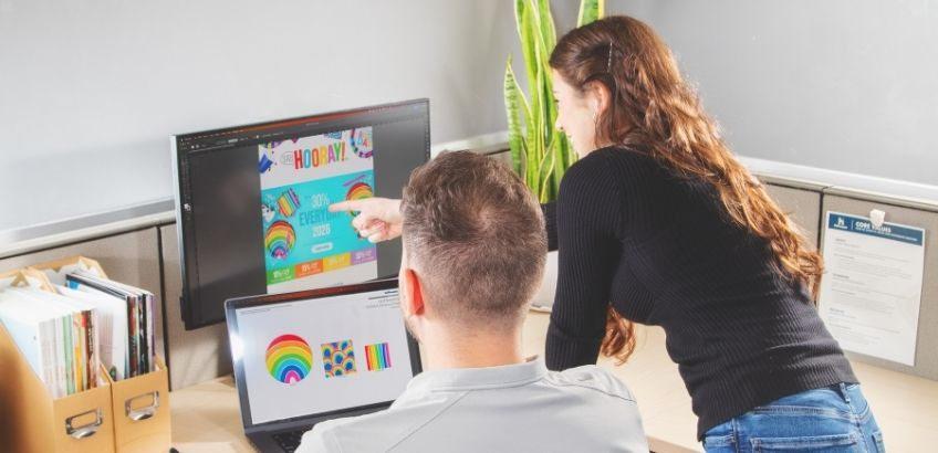 Two designers reviewing designs at a computer